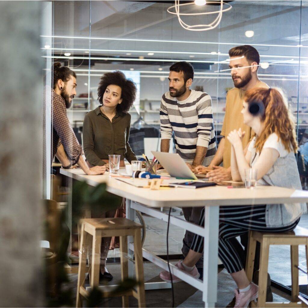 A team discussing work matters around a long, rectangular table.