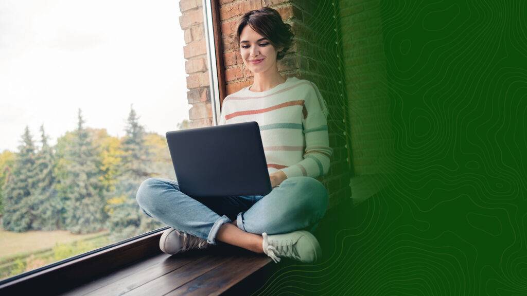 A woman using her laptop to attend online school.