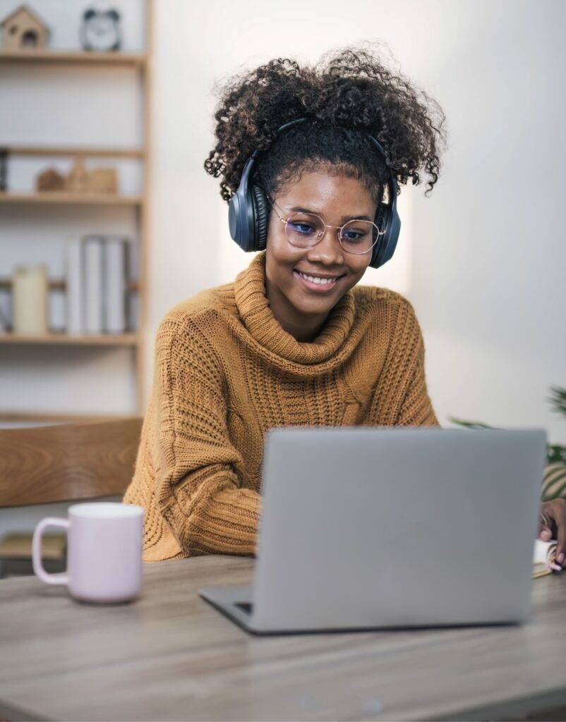 A woman using her laptop to attend online school.